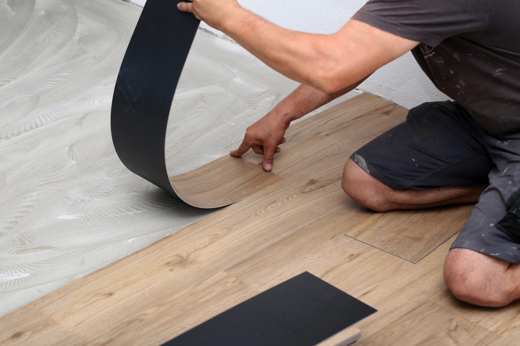 Worker installing vinyl tile floor